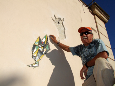 Un operari al costat d'una peça del mural