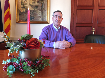 El batle, assegut a la taula del seu despatx.