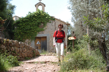 Una senderista transita pel costat de l'oratori.