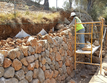 Un operari treballant a un mur del Coll de Sóller.
