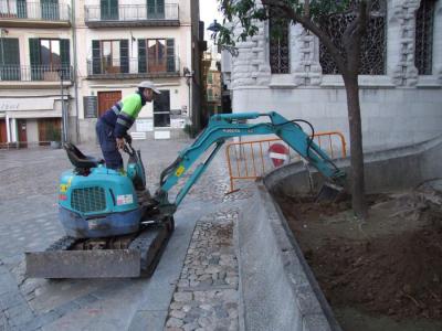 Un operari treballant en el jardí parroquial