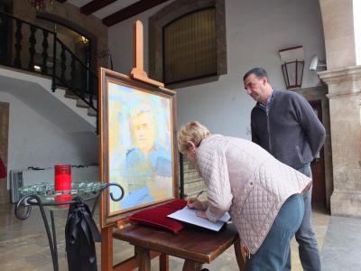 El batle observa com una ciutadana firma el llibre