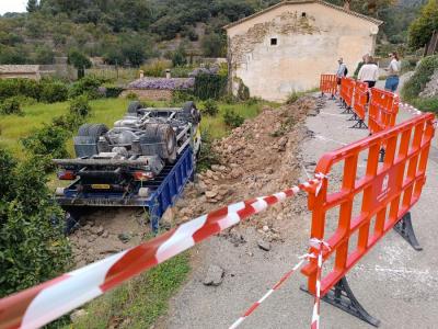 Uns turistes objservant el camió trabucat