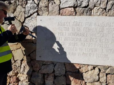 Un operari retirant la placa inaugural.