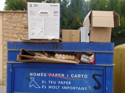 Imatge d'un contenidor de paper i cartró amb residus.