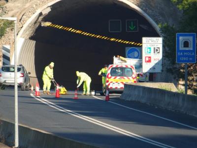 Els operaris aplicant l'asfalt als clots