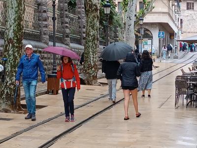 Vianants, pel Born, baix el paraigües