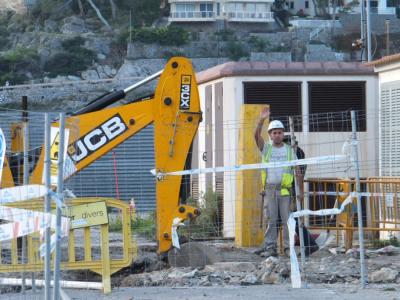Uns operaris al costat de l'excavadora