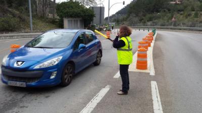 Una treballadora del túnel, donant via lliure als vehicles.