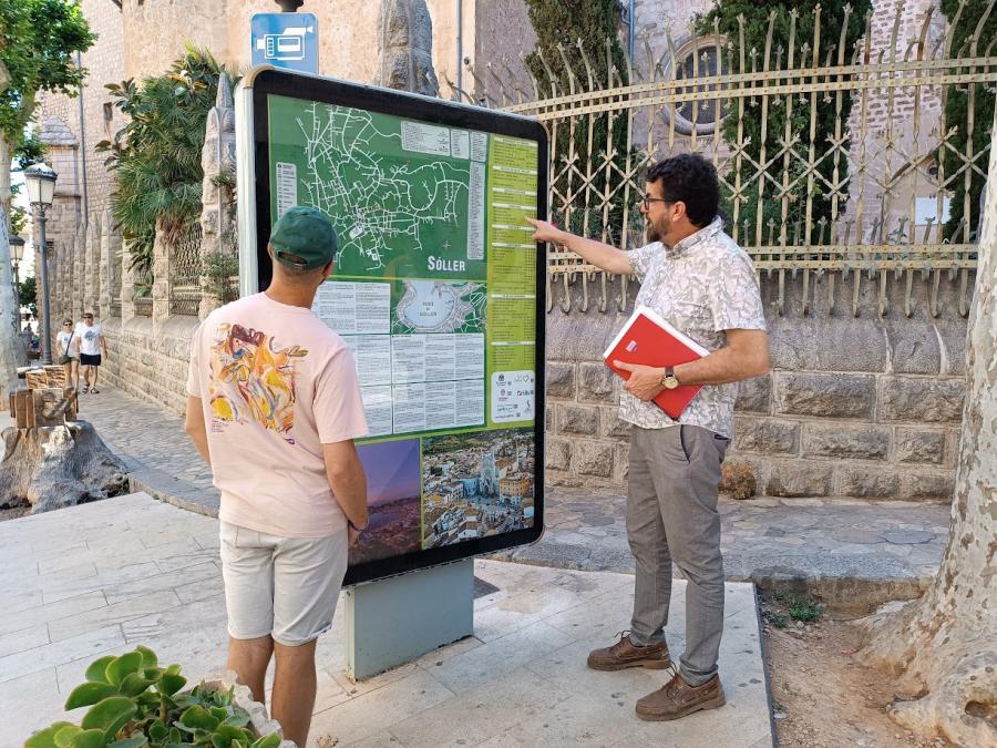 Aguiló i un turista observant el panell