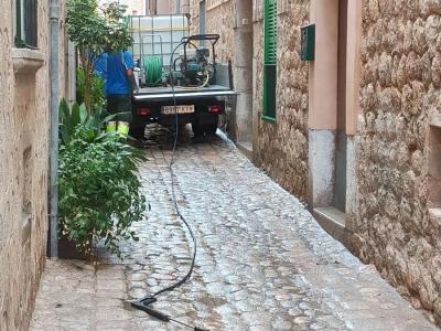 Uns operaris netejant el carrer de Vives