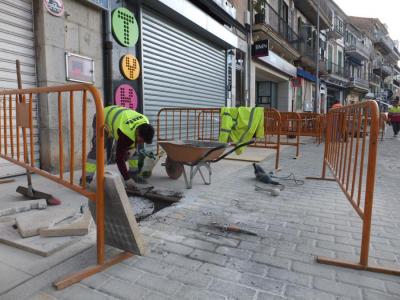 Els operaris treballant en la pavimentació de la vorera