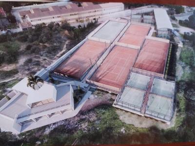 Imatge de la instal·lació amb l'edifici de serveis en primer pla, i al fons, les noves pistes i la pèrgola.