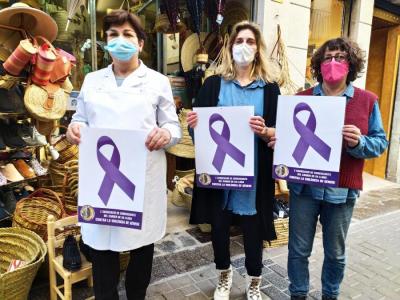 Tres botigueres de Sa Lluna subjectant cartells