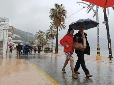 Turistes passejant baix el paraigües al Port