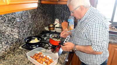 Un particular cuinant els bunyols a la cuina de casa seva.